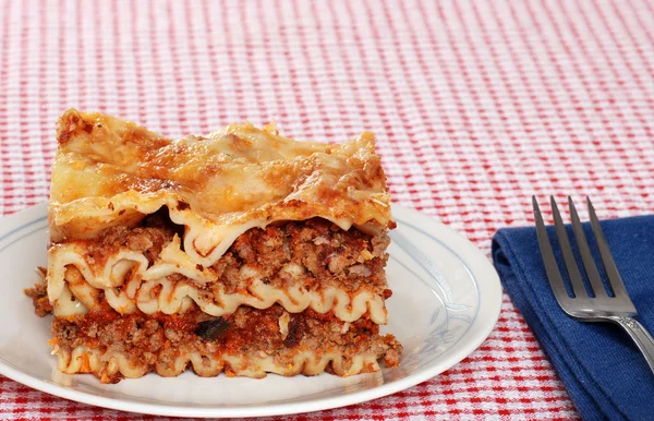 Lasagna with napkin and fork — Stock Photo, Image