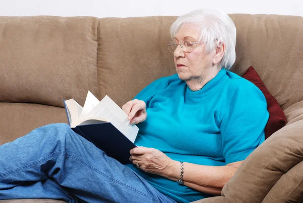 Senior woman turning pages of a book — Stock Photo, Image