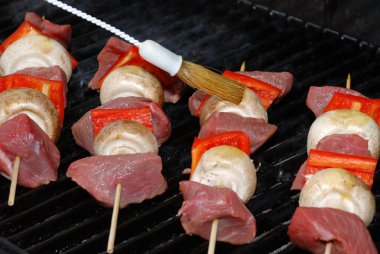 Cooking beef kabobs on barbecue focus on brush clipart