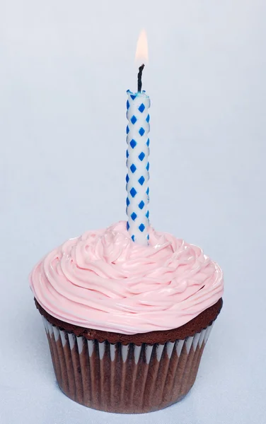 Bolo de chocolate com cobertura rosa e vela de aniversário — Fotografia de Stock