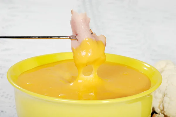 Sumergiendo jamón en fondue de queso — Foto de Stock