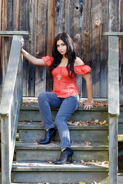 Donna ispanica seduta su gradini di legno — Foto Stock