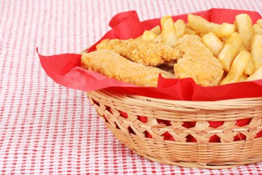 Chicken fingers and french fries in a basket clipart