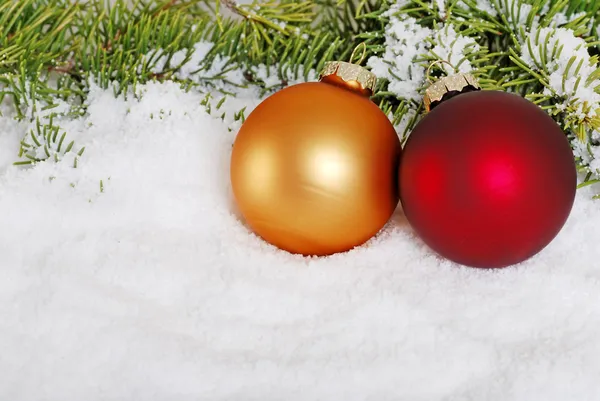 Χρυσό και κόκκινο μπάλα Χριστούγεννα στο χιόνι — Φωτογραφία Αρχείου