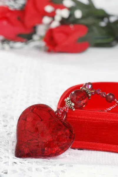 Macro red heart jewelry leaning on box — Stock Photo, Image