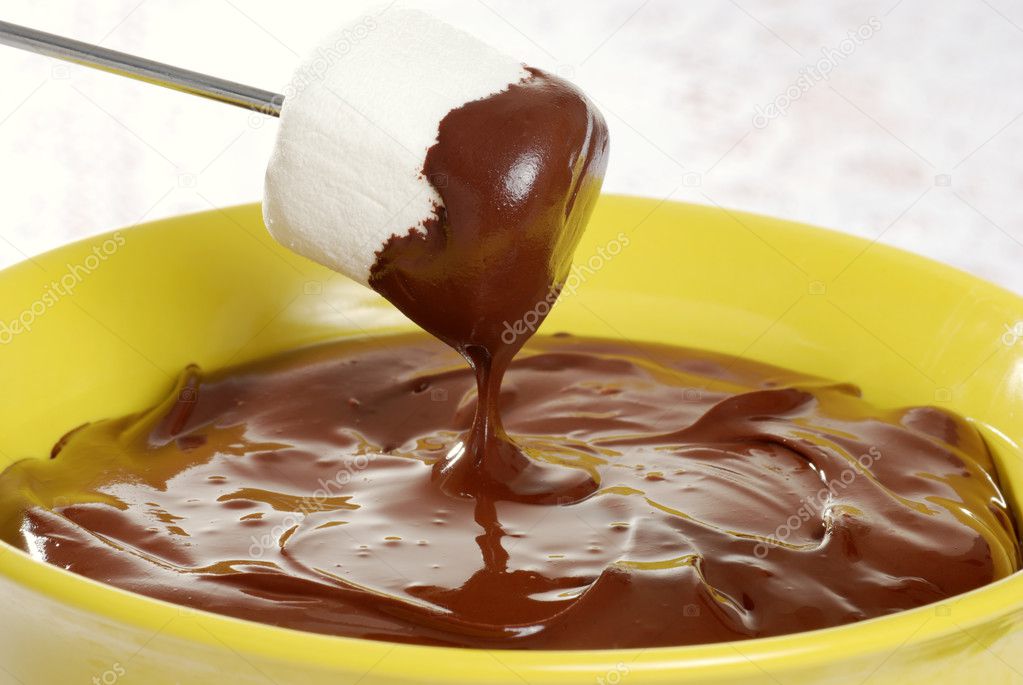 Dipping marshmallow in chocolate fondue