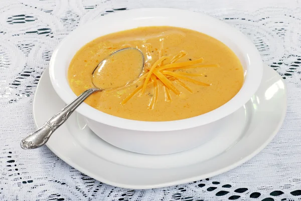 Ложка отдыхает в сырном супе — стоковое фото