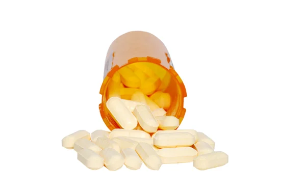 Gelbe Pillen und orangefarbene Flasche isoliert — Stockfoto