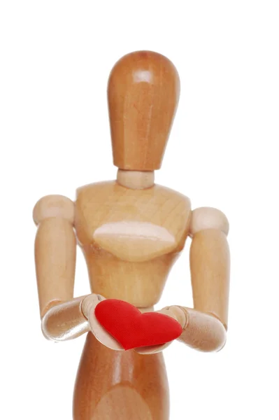 Figura de madeira segurando as mãos foco coração vermelho — Fotografia de Stock