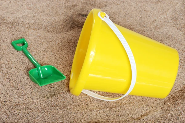 Gelbe Kindereimer im Sand — Stockfoto