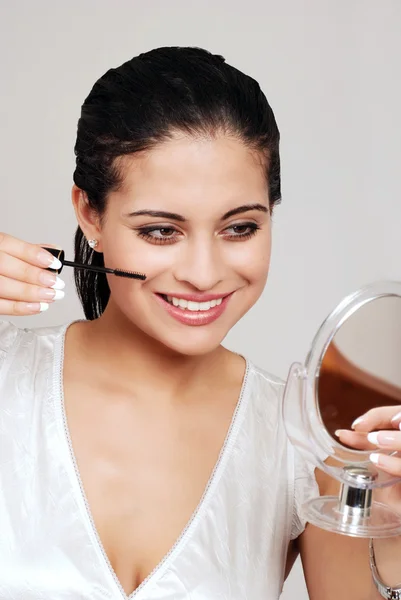 Young woman putting on mascara — Stock Photo, Image