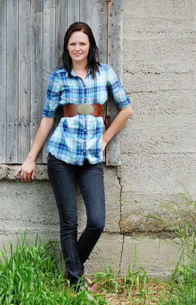 Young woman leaning on barn — Stock Photo, Image