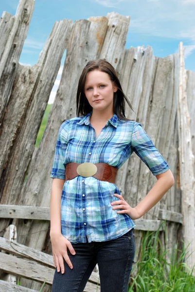 Young woman standing near old wood post fence — Stock Photo, Image