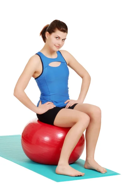 Brunett kvinna leende sitter på övning boll — Stockfoto