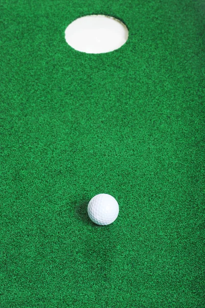 구멍의 짧은 골프 공 — 스톡 사진