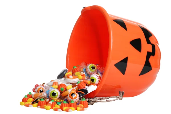 Criança halloween abóbora balde derramando doces — Fotografia de Stock