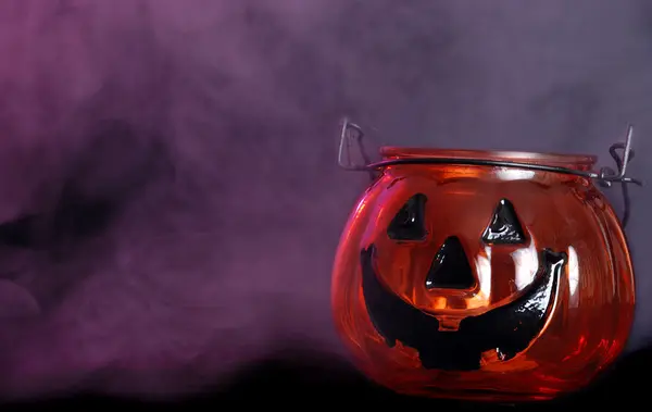 Glass halloween pumpkin candle holder with smoke — Stock Photo, Image