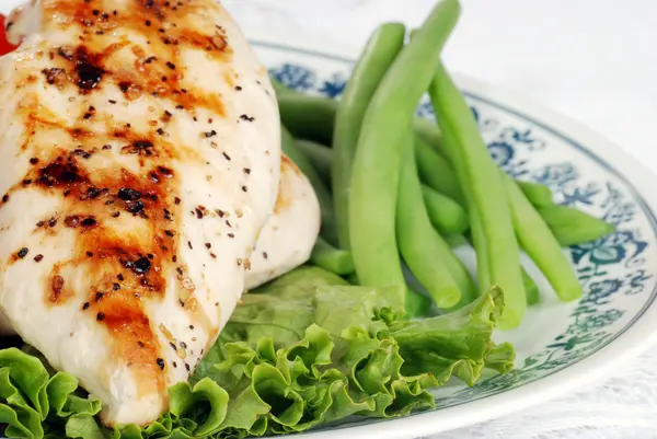 Macro grilled chicken with lettuce and green beans — Stock Photo, Image