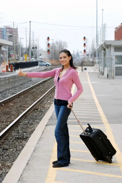 Woman hitchhiking at railroad station — Stock Photo, Image
