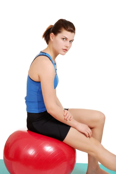 Mujer descansando sobre bola de ejercicio rojo — Foto de Stock