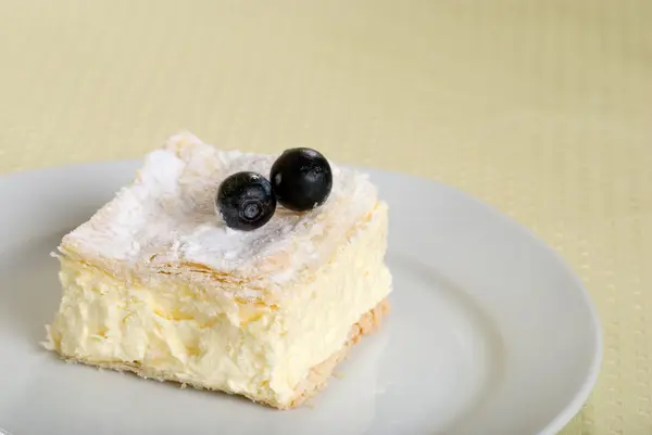 Πλατεία τούρτα κρέμα σε ένα πιάτο με φρέσκα μούρα — Φωτογραφία Αρχείου