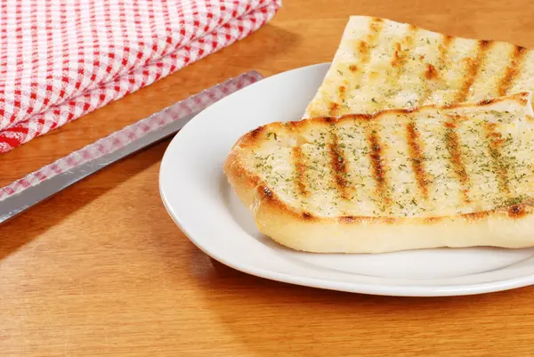 Garlic bread with knife — Stock Photo, Image