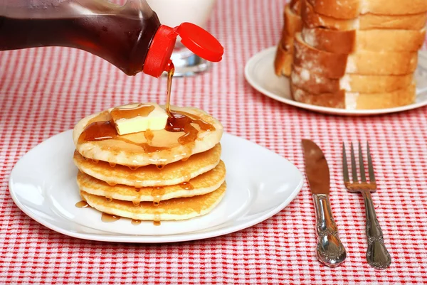 Ahornsirup wird auf einen Stapel Pfannkuchen gegossen — Stockfoto