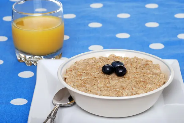 Oatmeal with blueberries focus on berries — Stock Photo, Image