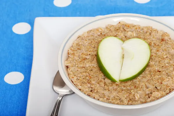 Oatmeal with heart shaped apple slices — Stock Photo, Image