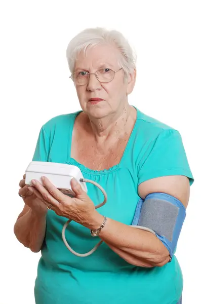 Senior vrouw met behulp van automatische bloeddruk machine — Stockfoto
