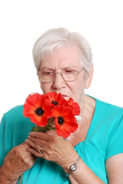 Mulher sênior com papoilas vermelhas artificiais — Fotografia de Stock