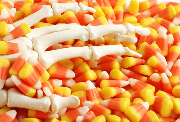Skeleton hand in candy corn — Stock Photo, Image