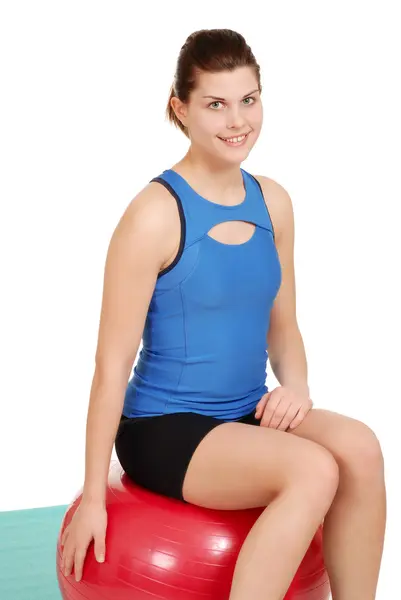 Egzersiz topu üzerinde oturan genç bir kadın — Stok fotoğraf