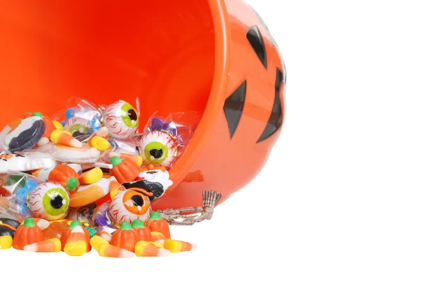 Macro spilled halloween candy and pumpkin bucket — Stock Photo, Image