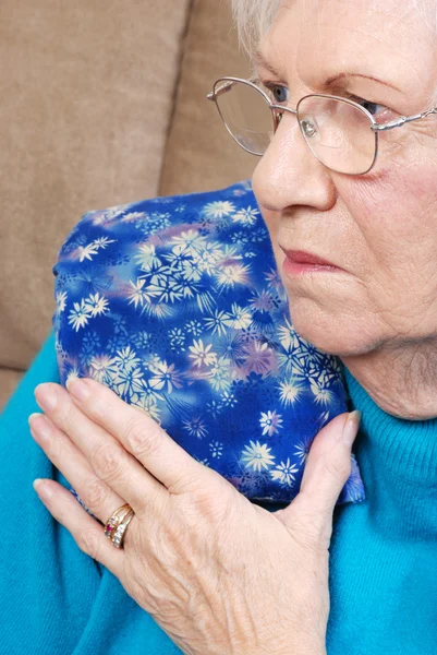 Senior woman with medical herb hot pack — Stock Photo, Image