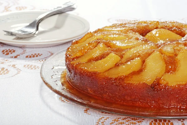 Upside down pear cake with plates and forks — Stock Photo, Image