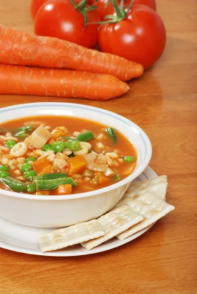 Vegetable soup with crackers and fresh carrots and tomato — Stock Photo, Image