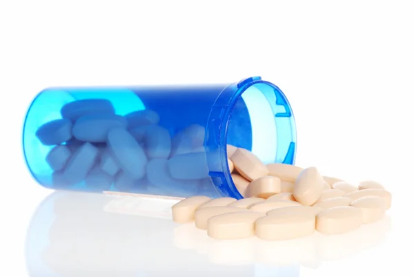 Píldoras vitamínicas en frasco azul — Foto de Stock