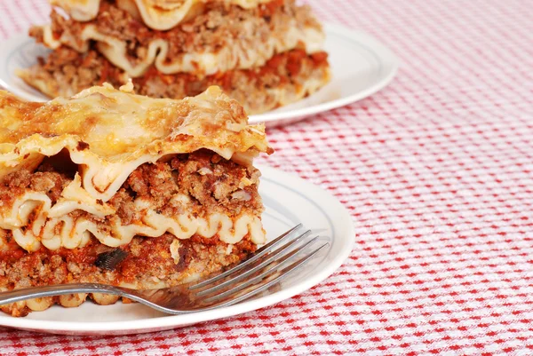 Lasagna on red and white tablecloth — Stock Photo, Image