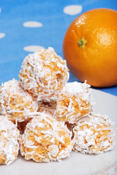 Orange snowball cookies with fruit in the background