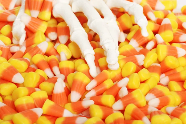 Mão de esqueleto e doces de Halloween — Fotografia de Stock