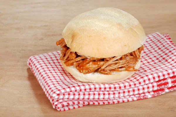 Barbacoa tiró sándwich de cerdo en servilleta roja y blanca — Foto de Stock