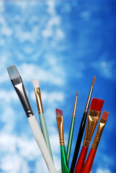 Pincéis de pintura sobre um fundo azul e branco — Fotografia de Stock