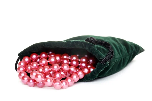 Perles roses dans un sac vert — Photo