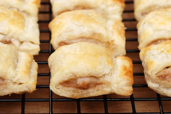 Sausage rolls on cooling rack — Stock Photo, Image