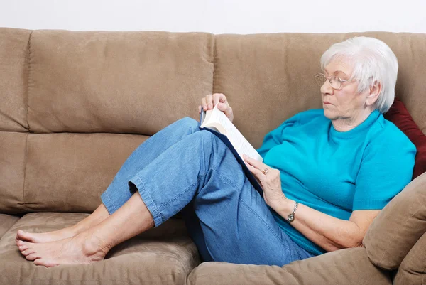Äldre kvinna faller en sömn medan du läser bok — Stockfoto