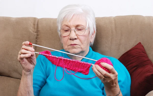 Seniorin legt ihre Stricksachen weg — Stockfoto
