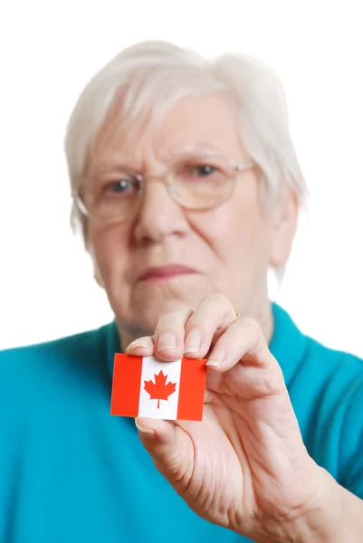 Donna anziana in possesso di bandiera giorno Canada concentrarsi su adesivo — Foto Stock