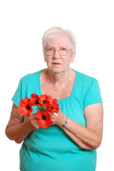 Seniorin hält falschen roten Mohn in der Hand — Stockfoto