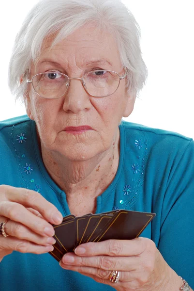 Старшая женщина держит игральные карты — стоковое фото